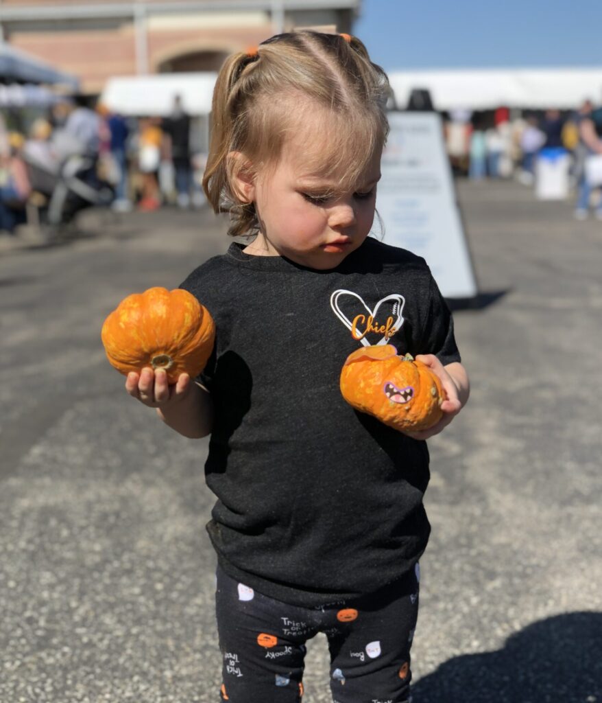 child with pumpkins event attraction